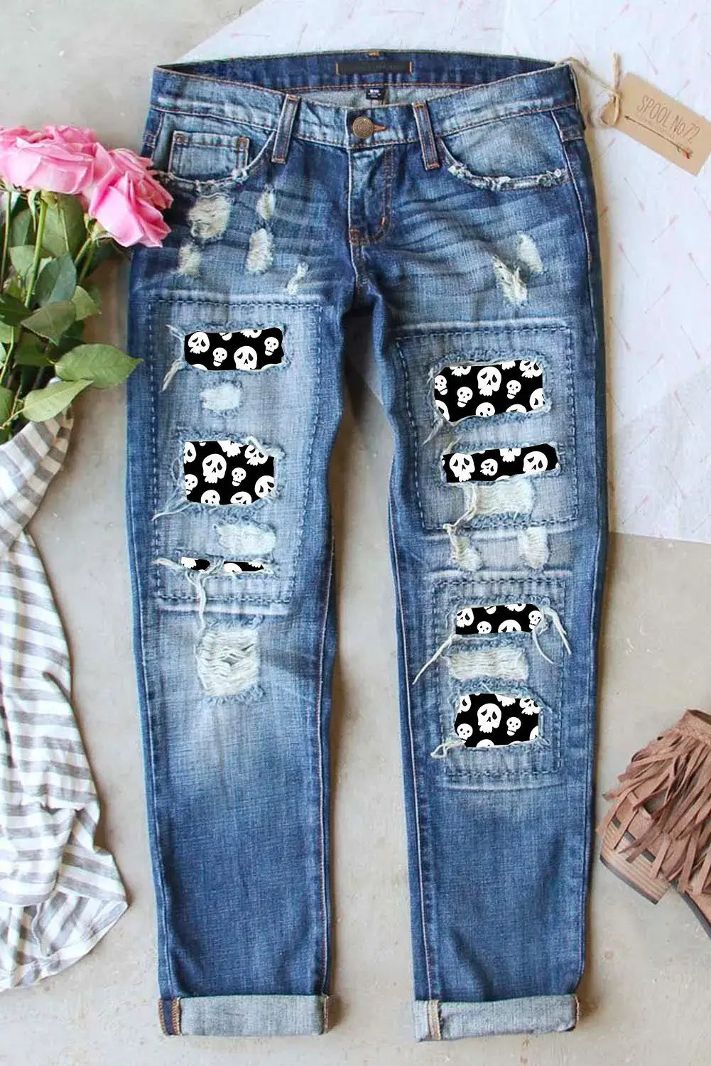 Distressed skeleton pattern jeans with pockets, featuring slightly stretchy material and made from a cotton-polyester blend.