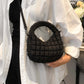 Woman wearing a white shirt and holding a Bella Road Quilted Puffy Crossbody Bag with a removable strap, showcasing its small size and style.