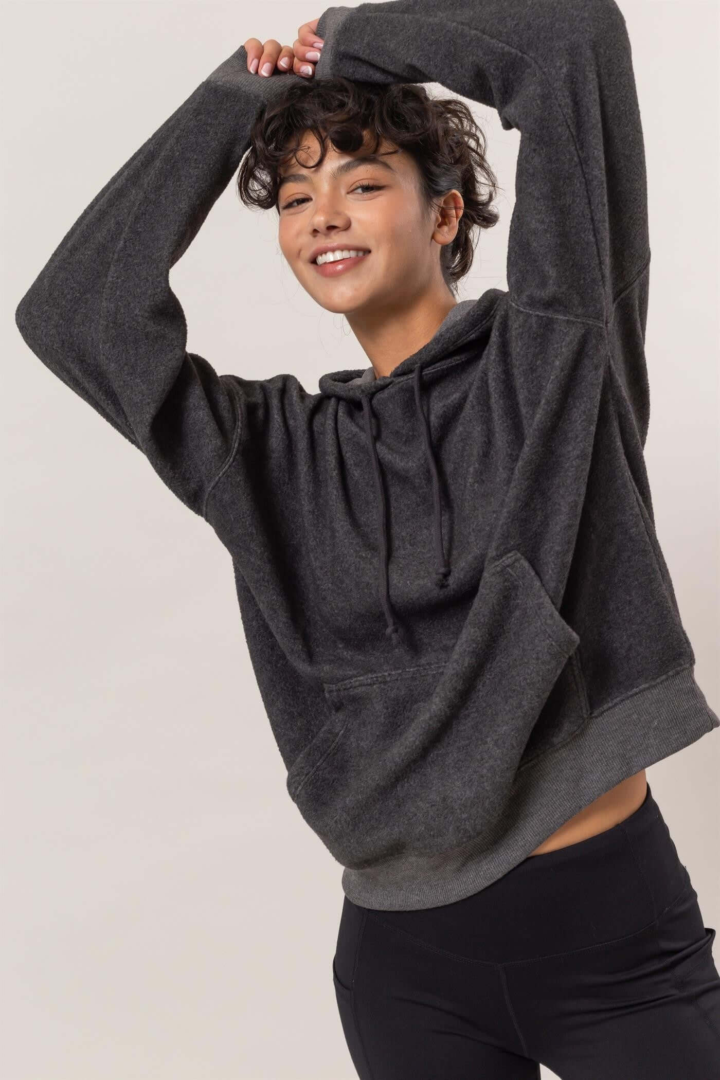 Cheerful model in a cozy brushed long sleeve hoodie with kangaroo pocket, perfect for chilly days and casual outings.