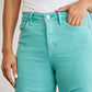 Woman wearing RFM Jeans Crop Chloe Tummy Control High Waist Raw Hem Jeans in green, showcasing sleek slim silhouette.