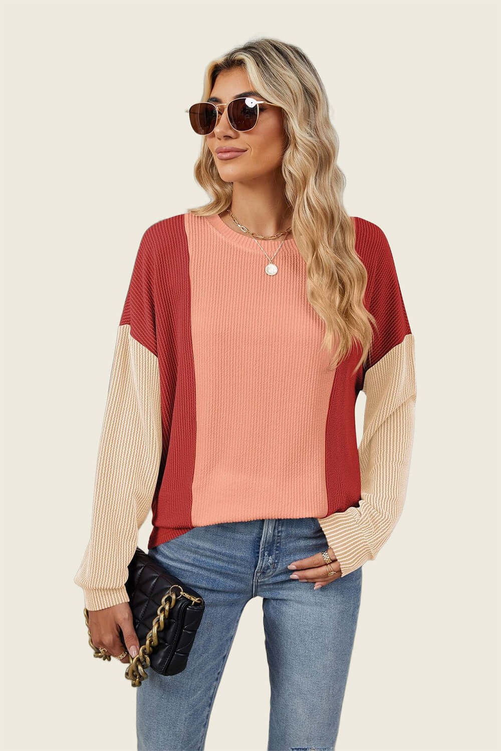 Woman in Double Take Texture Contrast Round Neck Long Sleeve T-Shirt, trendy color combo, holding a black handbag, wearing sunglasses.