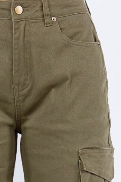 Close-up of olive green high rise cargo pants featuring button details and utility pockets.