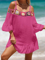 Woman wearing crochet cold shoulder three-quarter sleeve cover-up with ruffled sheer detail in pink on a beach.