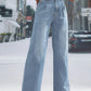 Woman wearing light blue wide leg jeans with pockets, standing on a city street, showcasing the relaxed fit and high waist style.