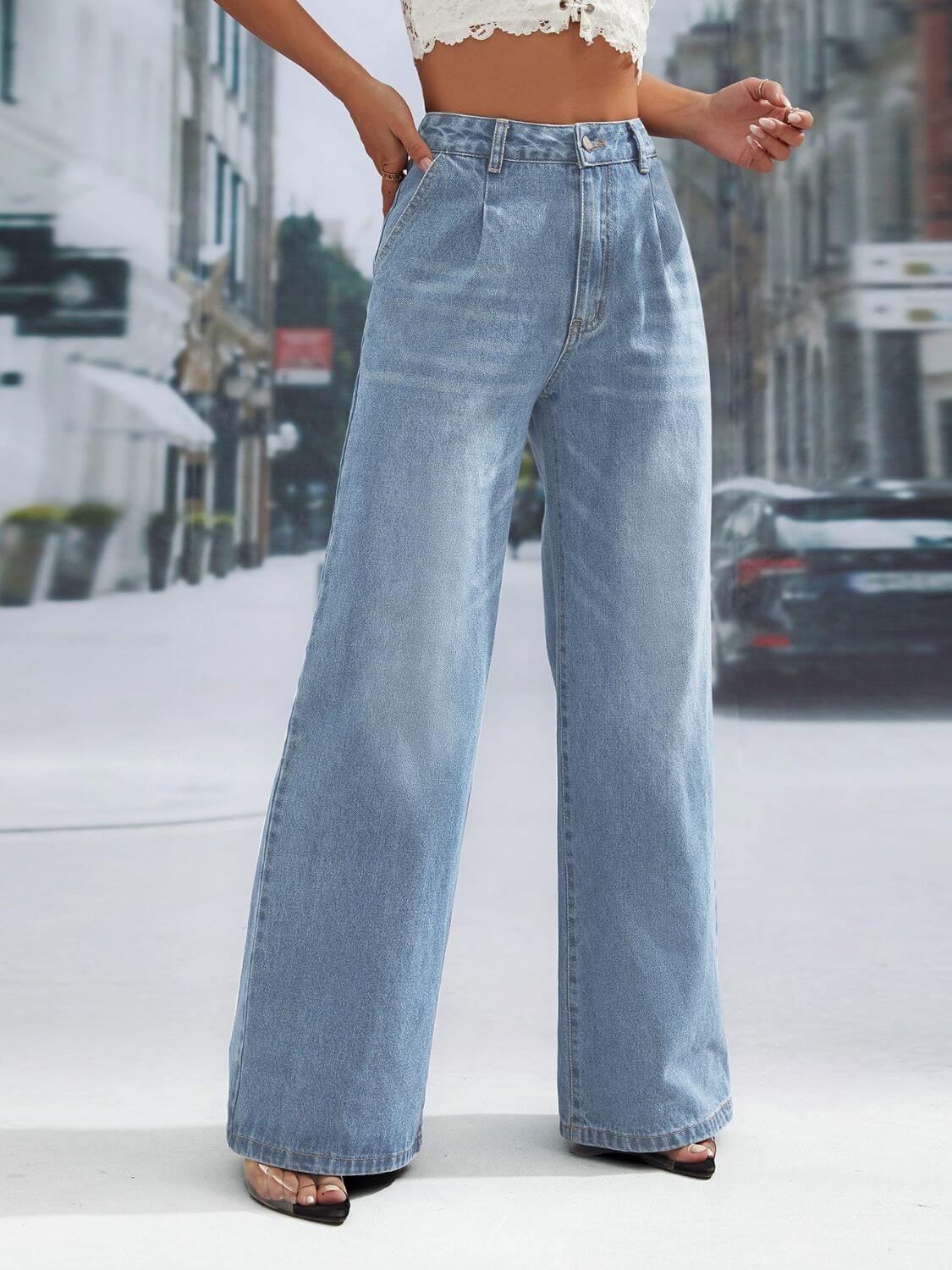 Woman wearing light blue wide leg jeans with pockets, standing on a city street, showcasing the relaxed fit and high waist style.