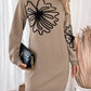 Woman wearing Perfee Flower Mock Neck Long Sleeve Sweater Dress holding a black clutch