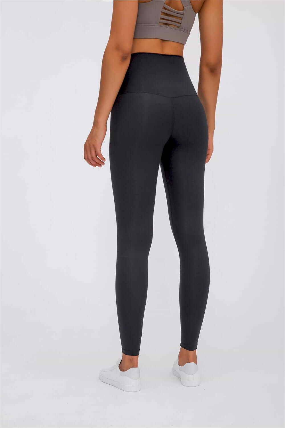 Model showcasing Millennia Ultra Soft High Waist Leggings from the back, paired with a sports bra and sneakers.