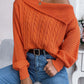 Woman wearing the Bella Road Cable-Knit One Shoulder Long Sleeve Sweater in orange, paired with high-waisted jeans, showcasing the trendy one-shoulder design