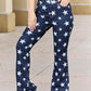 Woman wearing Janelle Full Size High Waist Star Print Flare Jeans by Judy Blue Jeans in dark wash with star pattern.