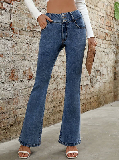 Bella Road bootcut denim jeans in medium wash with pockets, styled for a casual look against a textured wall.