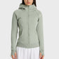 Model showcasing Millennia Zip Up Seam Detail Hooded Sports Jacket in soft green, perfect for outdoor activities.