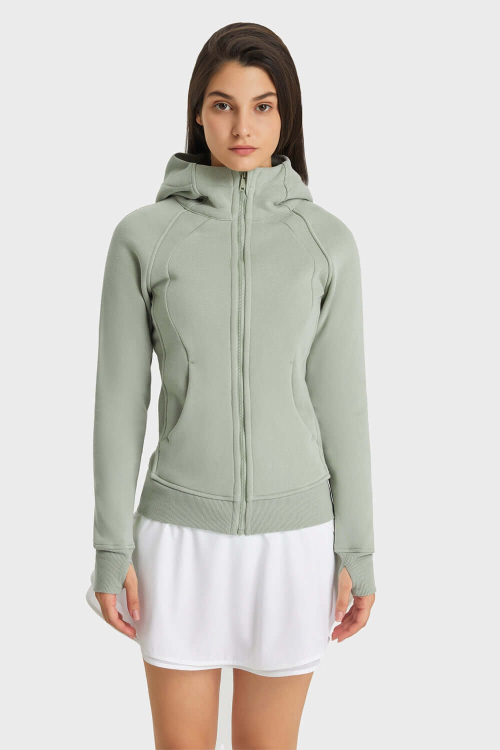 Model showcasing Millennia Zip Up Seam Detail Hooded Sports Jacket in soft green, perfect for outdoor activities.