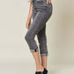 Woman modeling Judy Blue Jeans button fly high waist cuffed capris in gray, highlighting trendy and comfortable design.