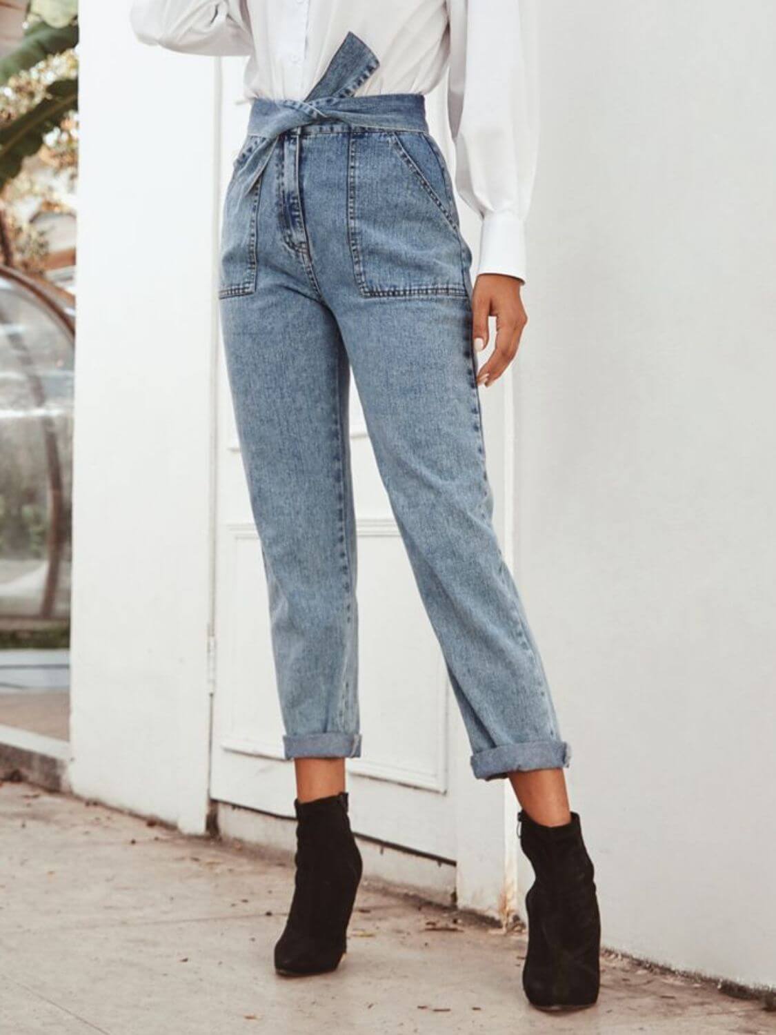 Fashionista in Bella Road Tied Straight Leg Jeans, featuring a stylish waist tie and convenient pockets, paired with chic black booties.