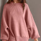 Woman wearing a cozy pink Double Take Side Slit Round Neck Long Sleeve Sweater with moderate stretch, made from 95% cotton and 5% polyester.