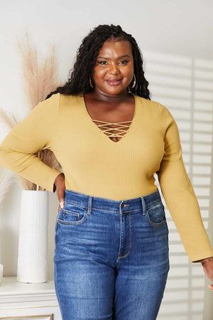 Woman wearing All About Details Full Size Ribbed Bodysuit with lace-up caged neck detail, paired with high-waisted jeans.