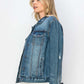 Stylish woman wearing a distressed denim button-up jacket, showcasing a trendy and rugged urban look.