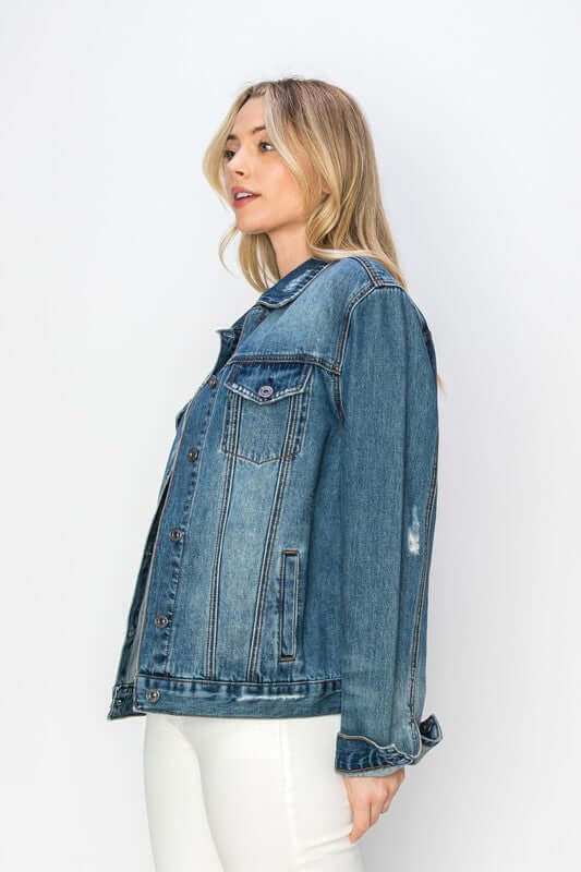 Stylish woman wearing a distressed denim button-up jacket, showcasing a trendy and rugged urban look.