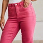 Person wearing Crop Dylan Full Size Tummy Control High Waist Raw Hem Jeans in bright pink color.