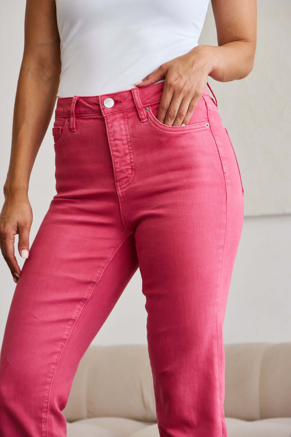 Person wearing Crop Dylan Full Size Tummy Control High Waist Raw Hem Jeans in bright pink color.