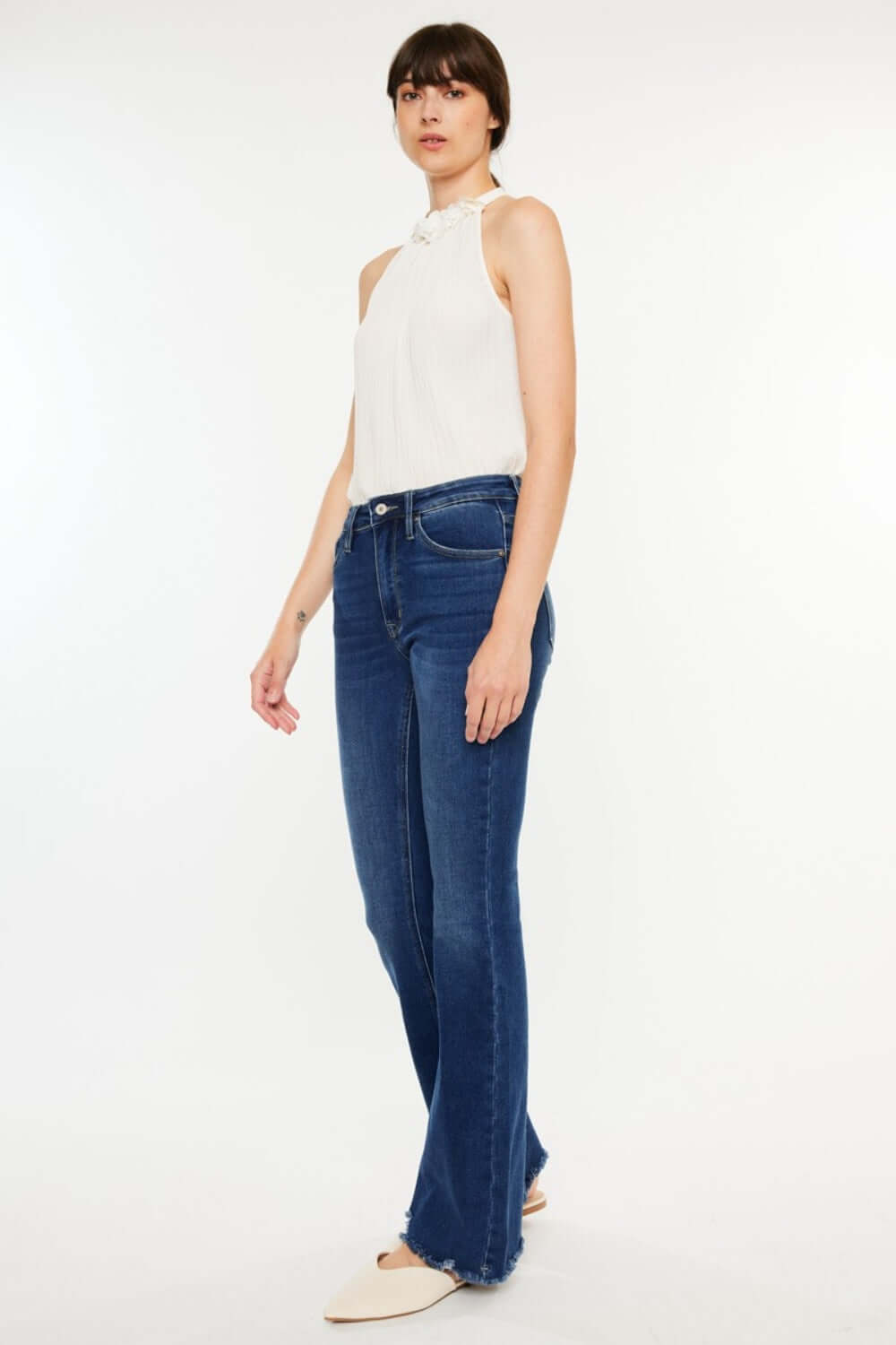 Fashion-forward model wearing Cat's Whiskers Raw Hem Flare Jeans, showcasing edgy sophistication and retro flare. Versatile and stylish denim.