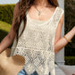 Model in a stylish cream crochet top, accessorized with a sun hat and earrings, perfect for beach days or summer outings.