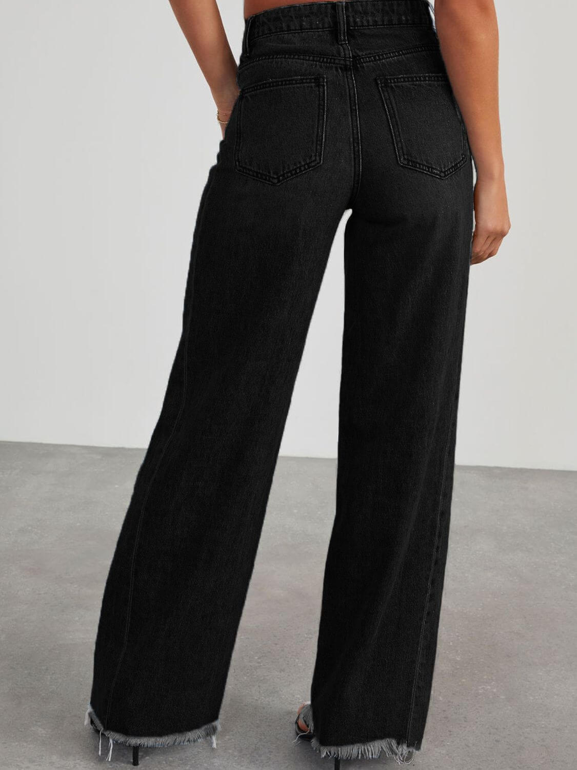 Back view of Bella Road raw hem wide leg jeans with pockets in black, no stretch.