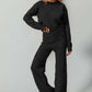 Stylish woman in a full-size checkered round neck top and pants set, showcasing edgy leisurewear in classic black with moderate stretch.