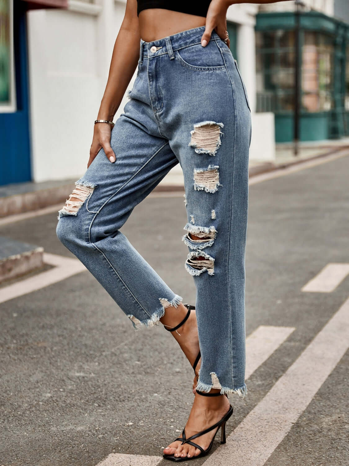 Woman wearing Bella Road Distressed Raw Hem Jeans with Pockets, slightly stretchy denim with ripped details, styled on city street.