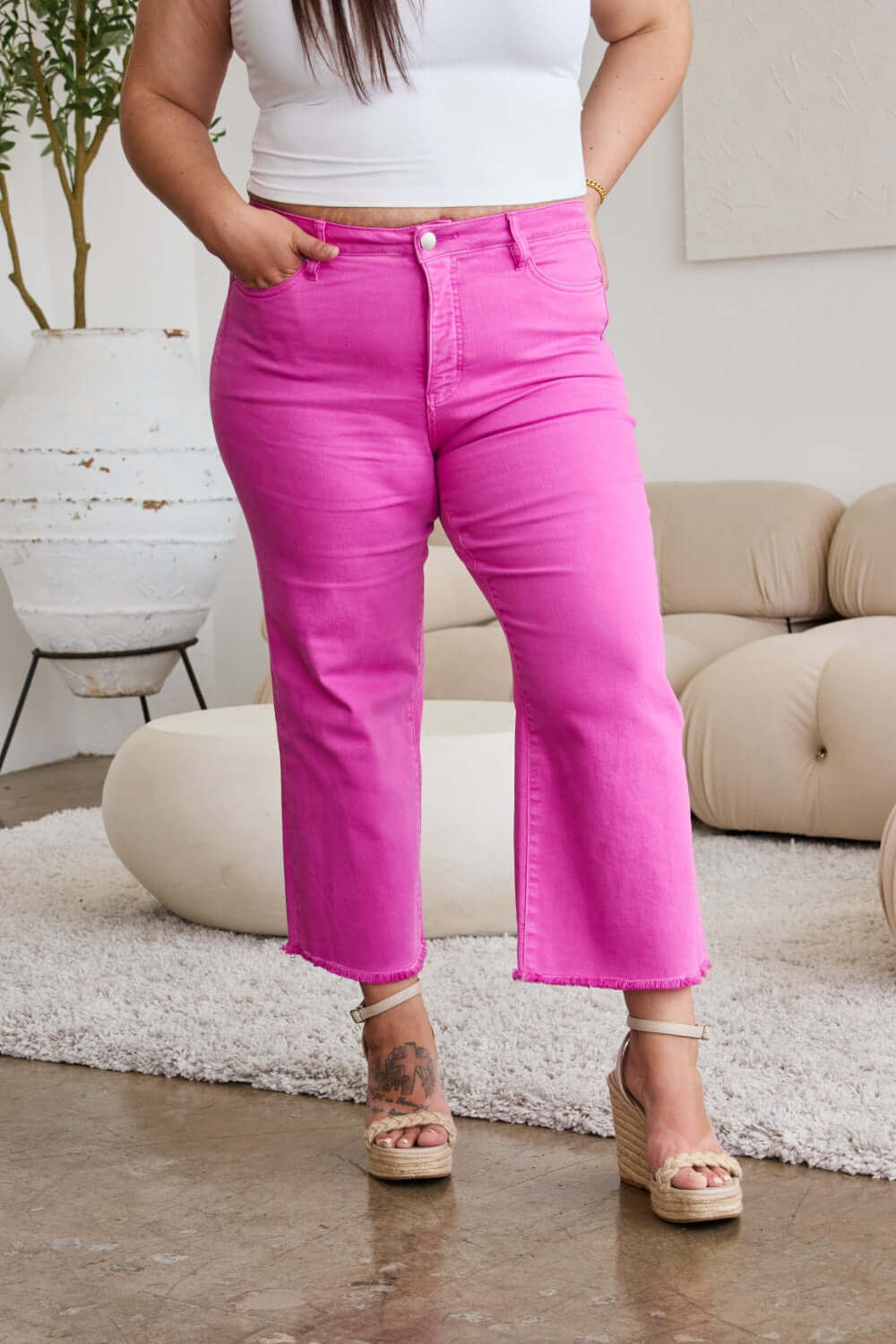 Woman wearing Crop Chloe Full Size Tummy Control High Waist Raw Hem Jeans in pink from RFM Jeans.