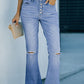 Woman wearing Bella Road Button-Fly Distressed Raw Hem Flare Jeans with a white top, holding a beige clutch, standing on a sidewalk