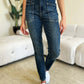 Woman wearing high waist skinny Judy Blue Jeans in dark denim with a modern skinny leg silhouette and front pockets, standing indoors.