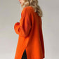 Woman wearing orange side slit turtleneck sweater with dropped shoulders, showcasing stylish and cozy fall fashion.