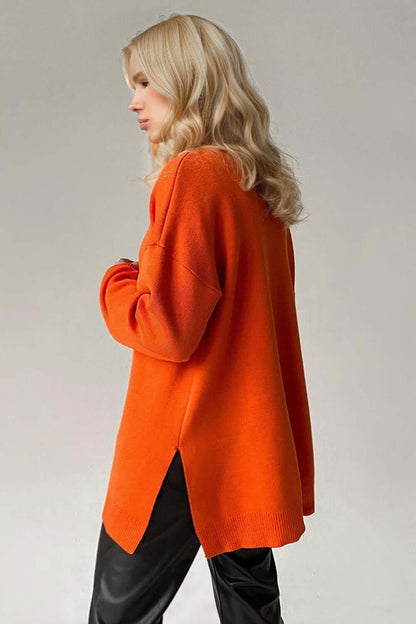 Woman wearing orange side slit turtleneck sweater with dropped shoulders, showcasing stylish and cozy fall fashion.