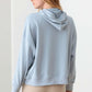 Woman wearing Tasha Apparel Half Zip Drawstring Mock Neck Hoodie in light blue, back view.