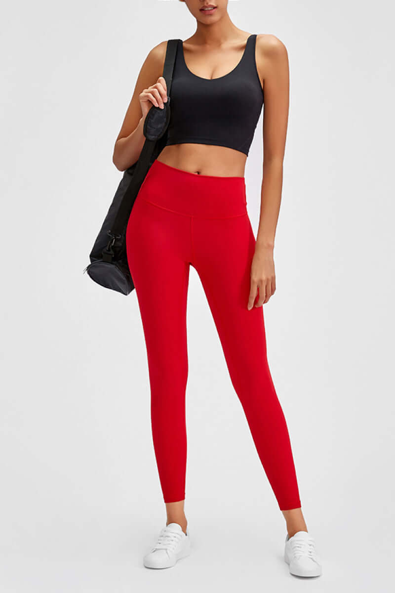 Millennia wide seamless band waist sports leggings in vibrant red, paired with a black crop top and athletic shoes.