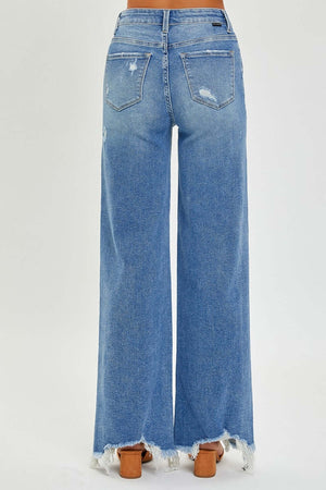 Back view of Risen Jeans high rise frayed hem wide leg jeans in blue denim, showcasing trendy vintage charm and edgy details.