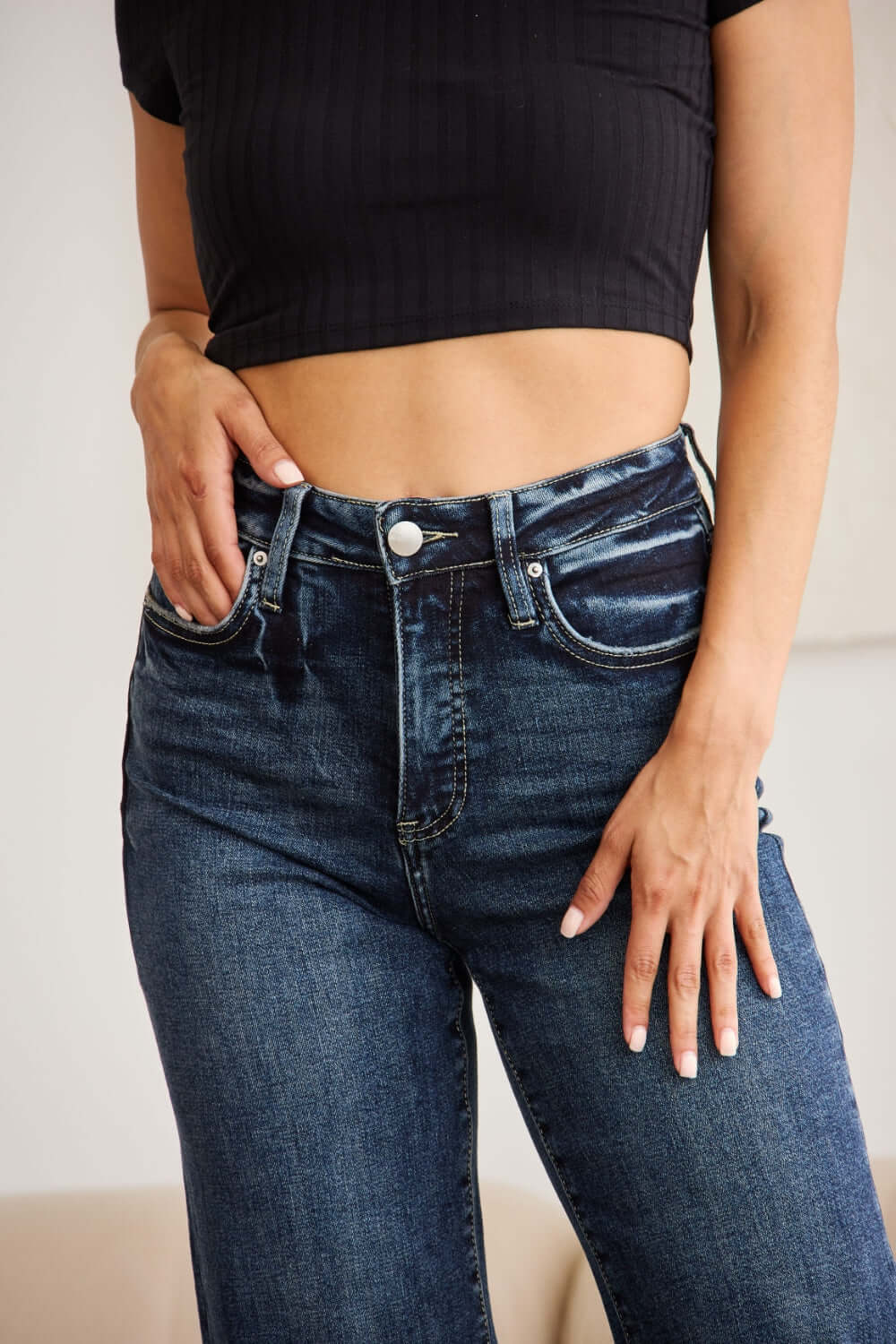 Woman wearing high waist raw hem jeans with tummy control and distressed detailing, showcasing a flattering and supportive fit. RFM Jeans.