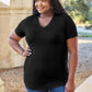 Woman wearing Basic Bae Bamboo V-Neck Short Sleeve T-Shirt in black, standing outdoors.