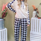 Stylish woman in a drawstring hooded top and plaid pants lounge set, showcasing trendy comfort for casual wear.