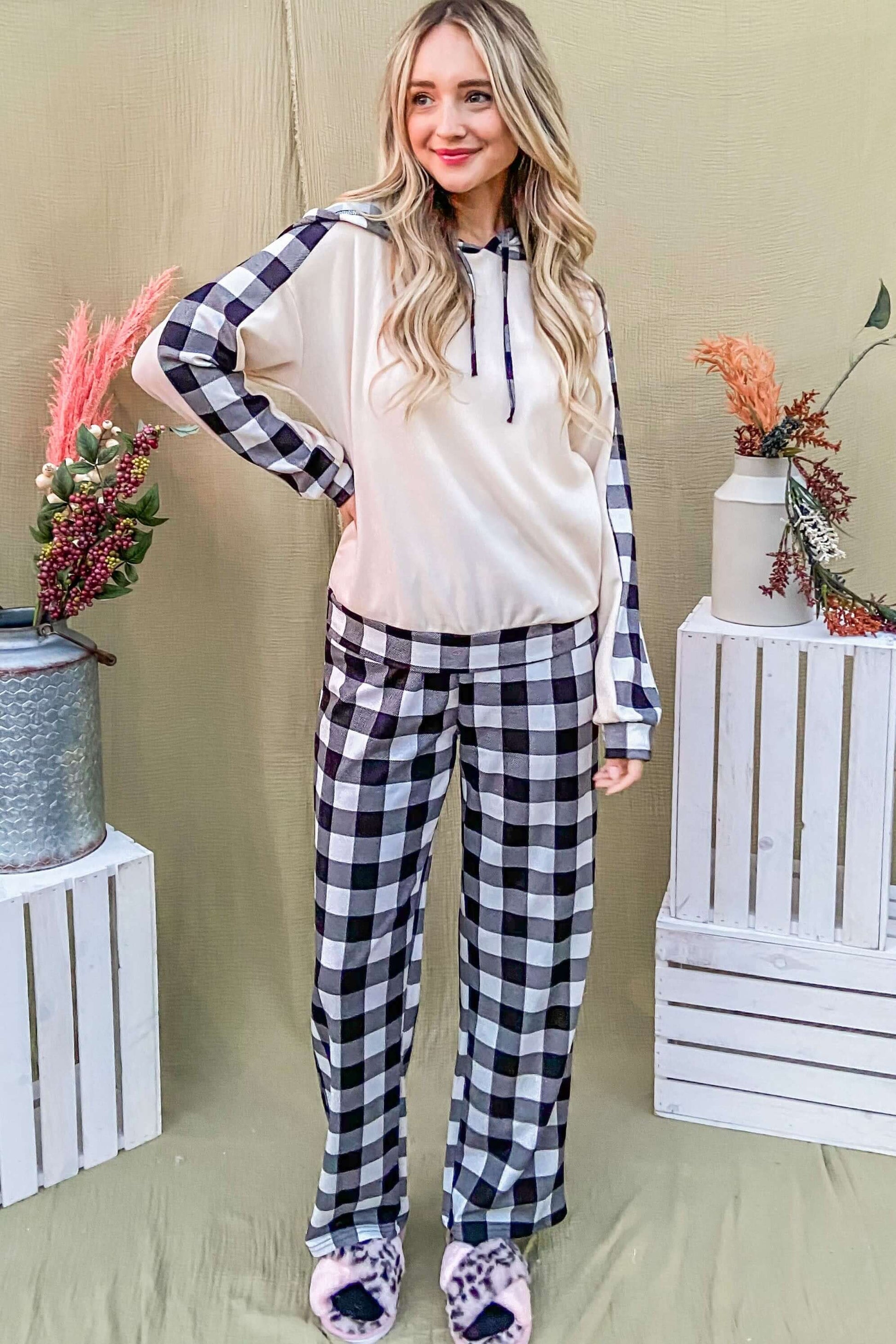 Stylish woman in a drawstring hooded top and plaid pants lounge set, showcasing trendy comfort for casual wear.