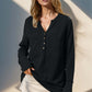 Woman wearing Double Take full size notched thumbhole long sleeve t-shirt in black with moderate stretch and buttoned neckline.