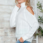 Woman wearing Bella Road Cable-Knit Turtleneck Cold Shoulder Sweater in white, showcasing trendy cut-out shoulder design.