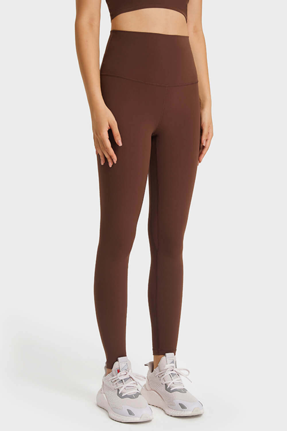 Ultra-soft high waist leggings in brown, paired with sneakers for a stylish athleisure look. Perfect for yoga or casual wear.