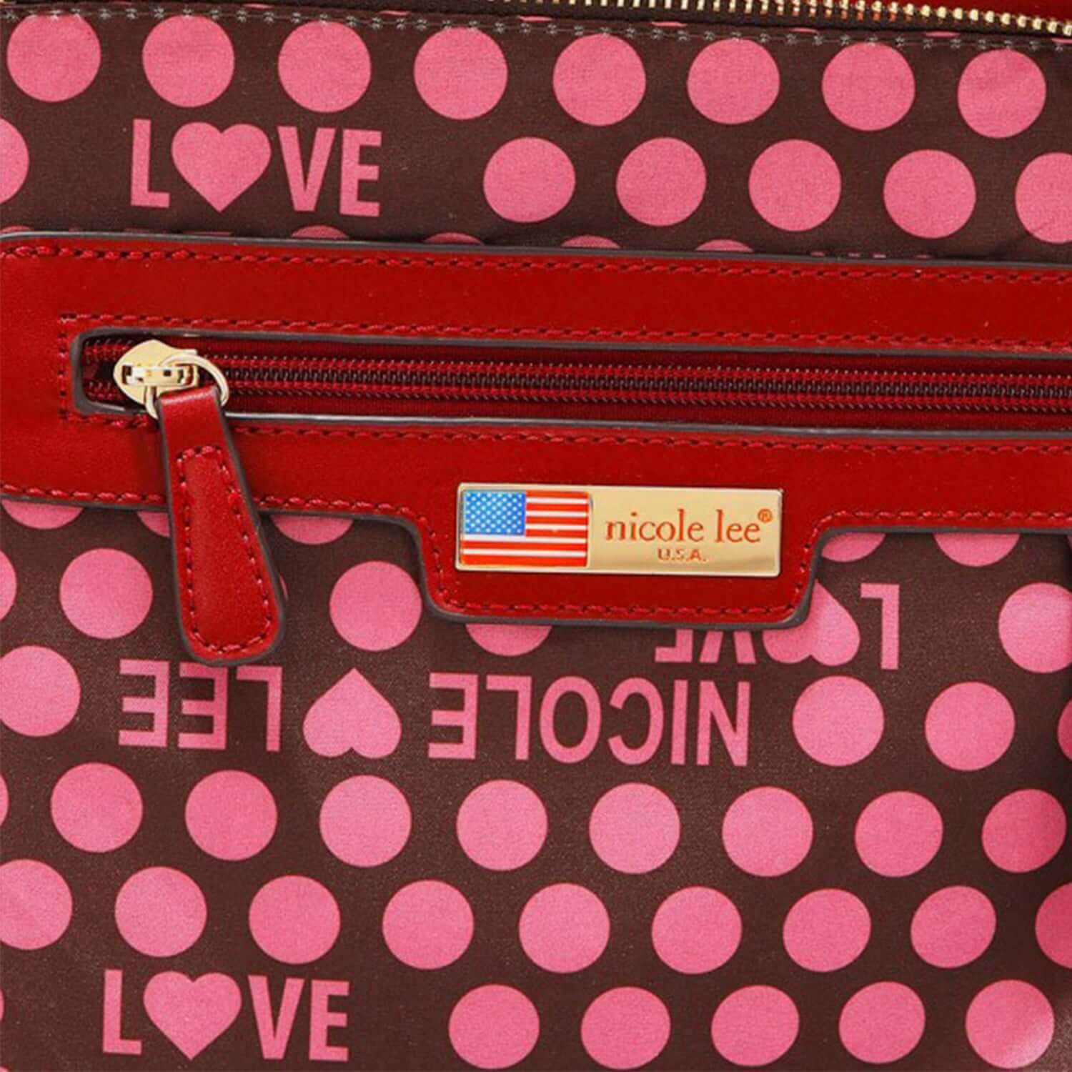 Close-up of Nicole Lee USA logo with red zipper on Scallop Stitched Boston Bag with pink polka dots and love hearts pattern