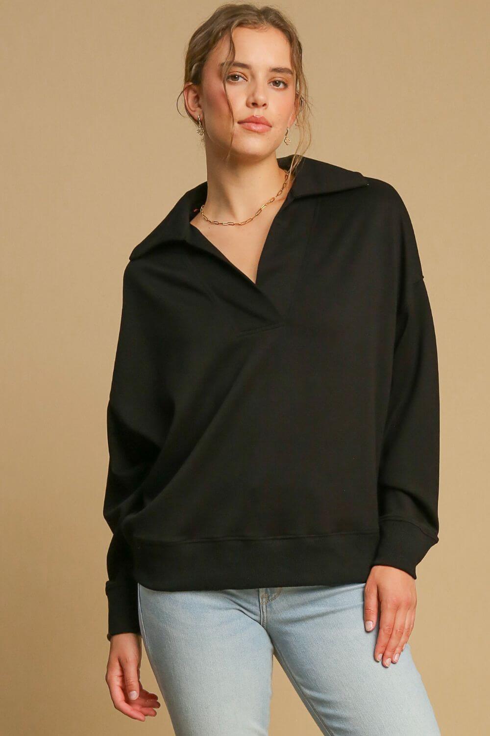 Stylish woman in black Umgee Johnny Collar Dropped Shoulder Sweatshirt, showcasing its relaxed fit and trendy design.