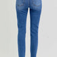 Back view of RISEN full size high rise ankle skinny knee distressed jeans with back pockets, showing a trendy and flattering fit