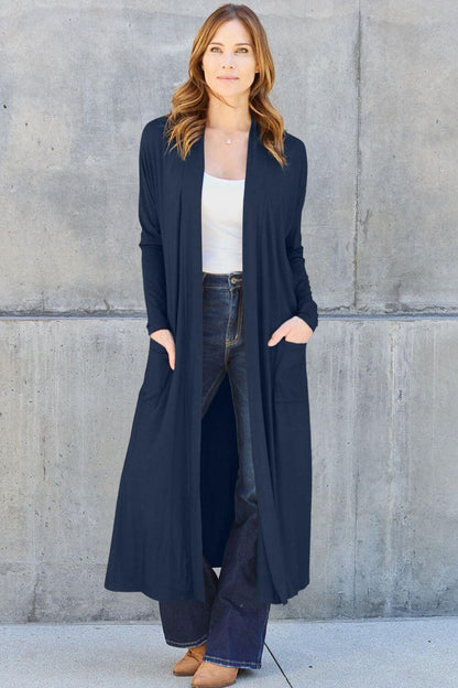 Woman wearing open front long sleeve cover up with pockets over jeans and top