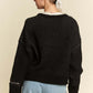 Back view of the Davi & Dani Contrast Heart Dropped Shoulder Sweater in black, styled with relaxed-fit jeans for a cozy look.