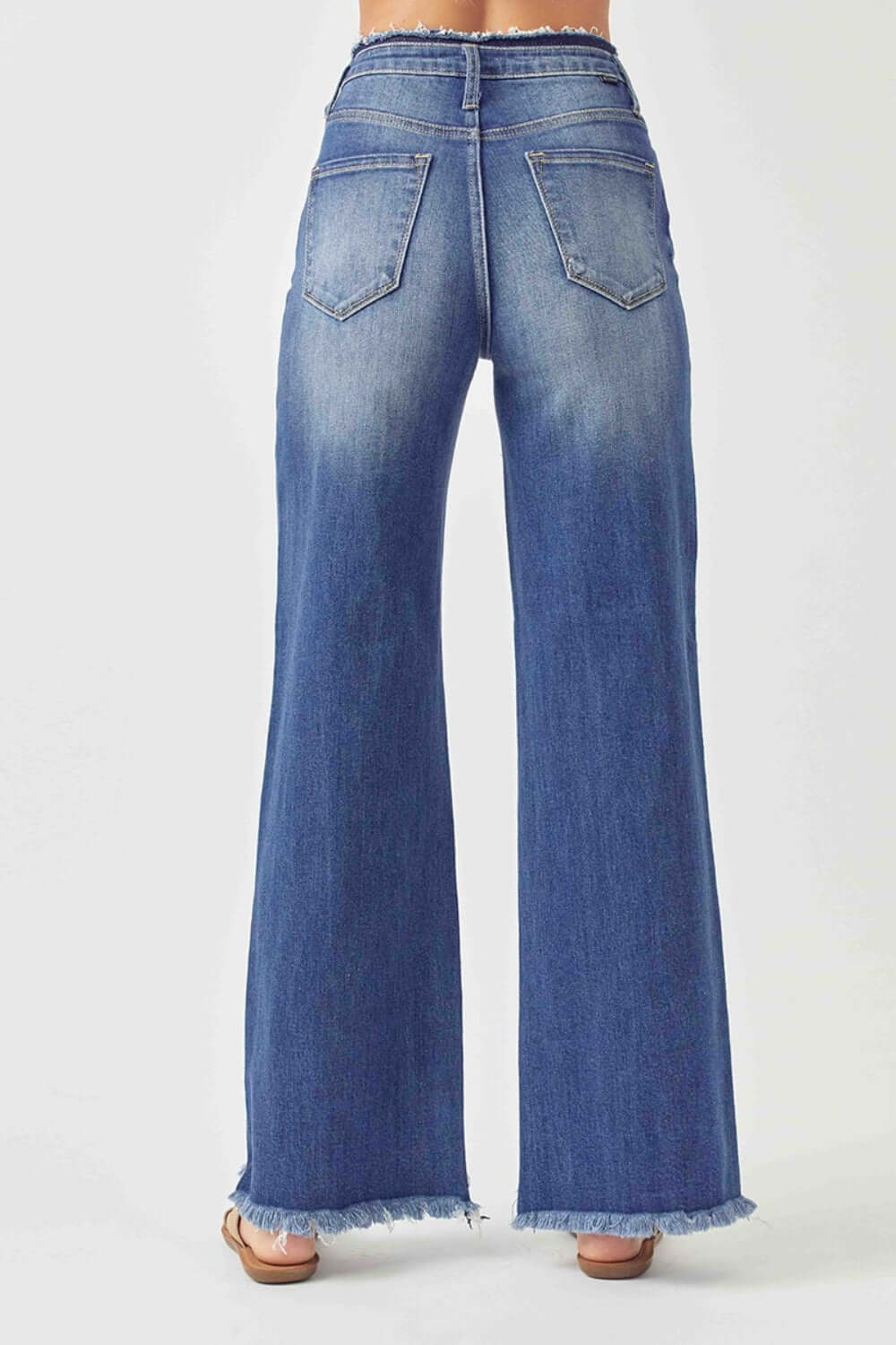 Back view of Risen Jeans high waist raw hem wide leg jeans showcasing trendy and chic denim style with flattering fit.